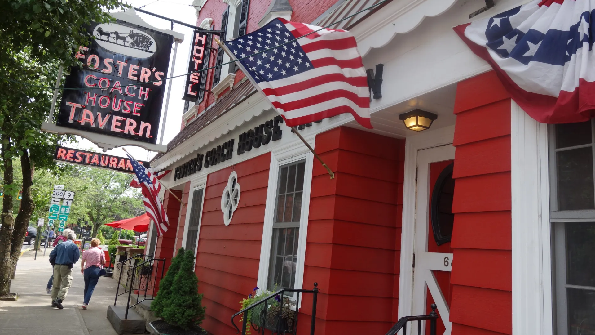 The red exterior of Foster's Coach Tavern in Rhinebeck with an American flag waving in the breeze.